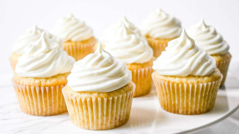Yellow cupcakes with white icing swirls.