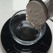 Flour poured into a bowl on a digital kitchen scale that reads 0g with the text how to measure flour.