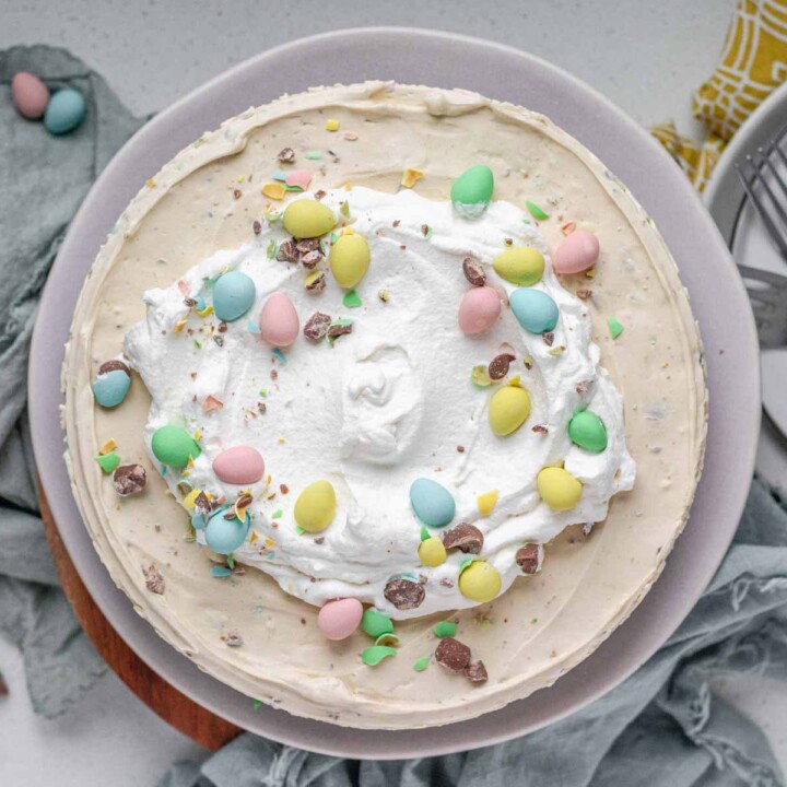 A cheesecake topped with whipped cream and mini eggs.