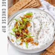 A bowl of white chunky dip with caramelized onion and sliced green onions with the text cottage cheese dip.