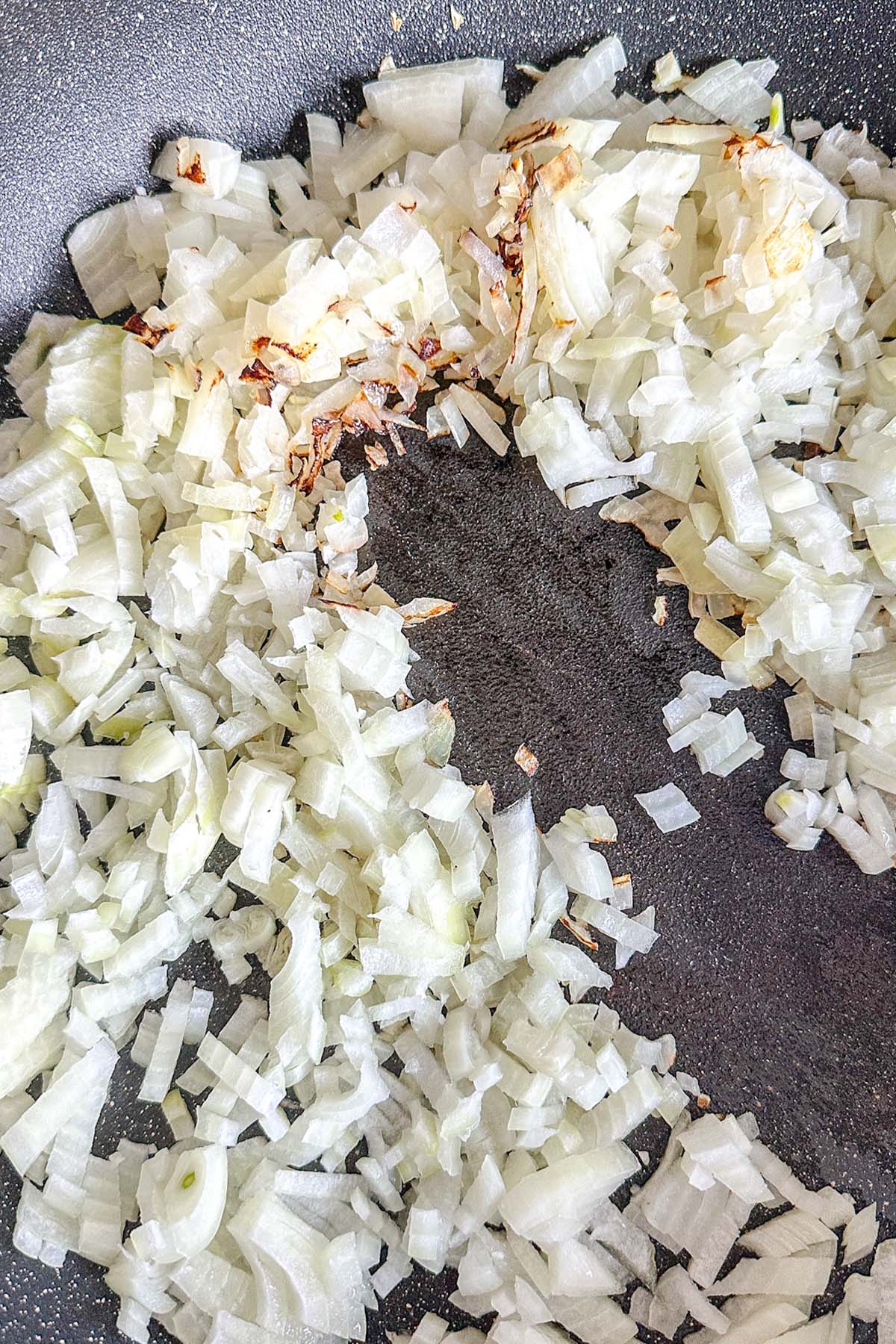 Onions frying in a skillet.