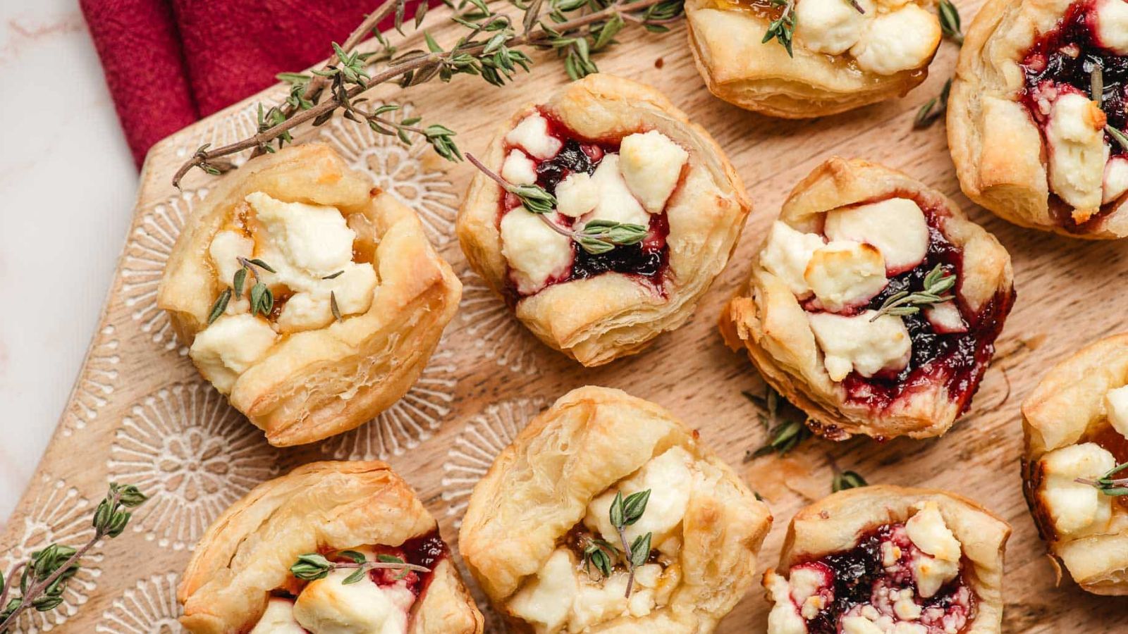 Puff pastry cups stuff with cheese and jam on platter.