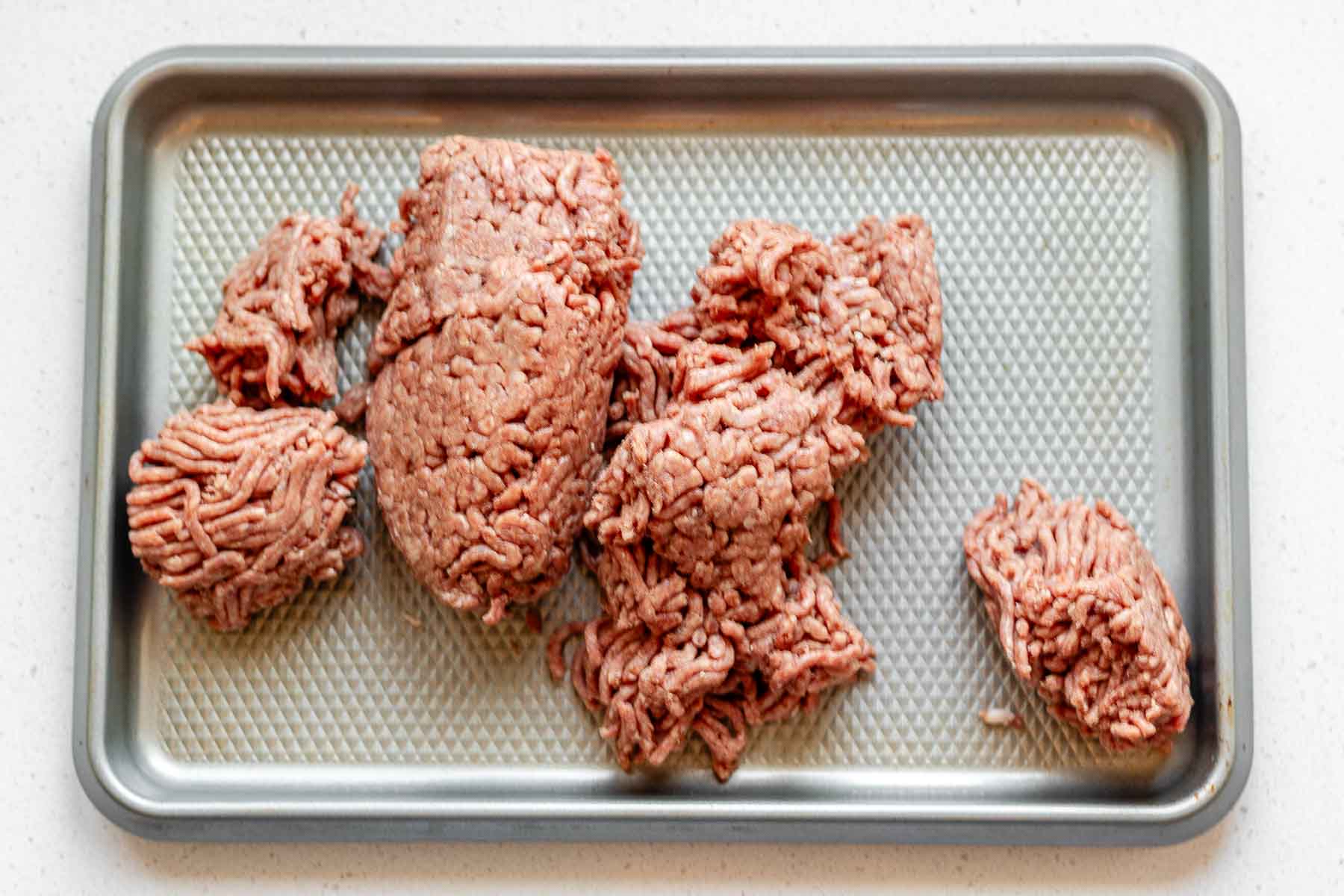 Ground beef on a sheet pan.