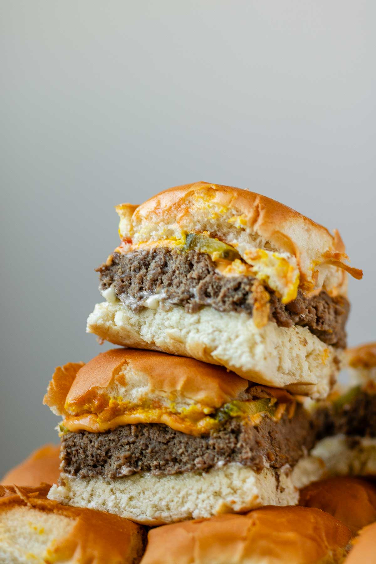 Mini burgers stacked in a pile.