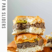 Mini burgers stacked in a pile with the text sheet pan sliders.