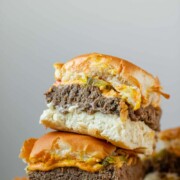 Mini burgers stacked in a pile with the text sheet pan sliders.