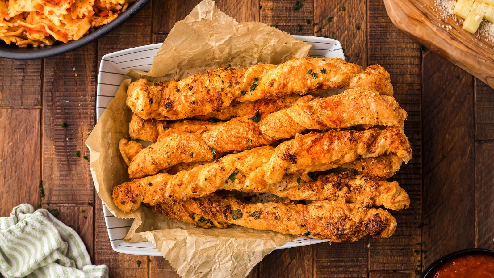 Puff pastry twists with cheese on them in a baking dish.