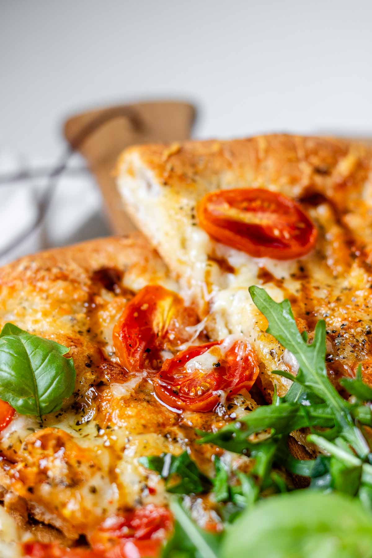 Pizza topped with arugula and basil leaves.