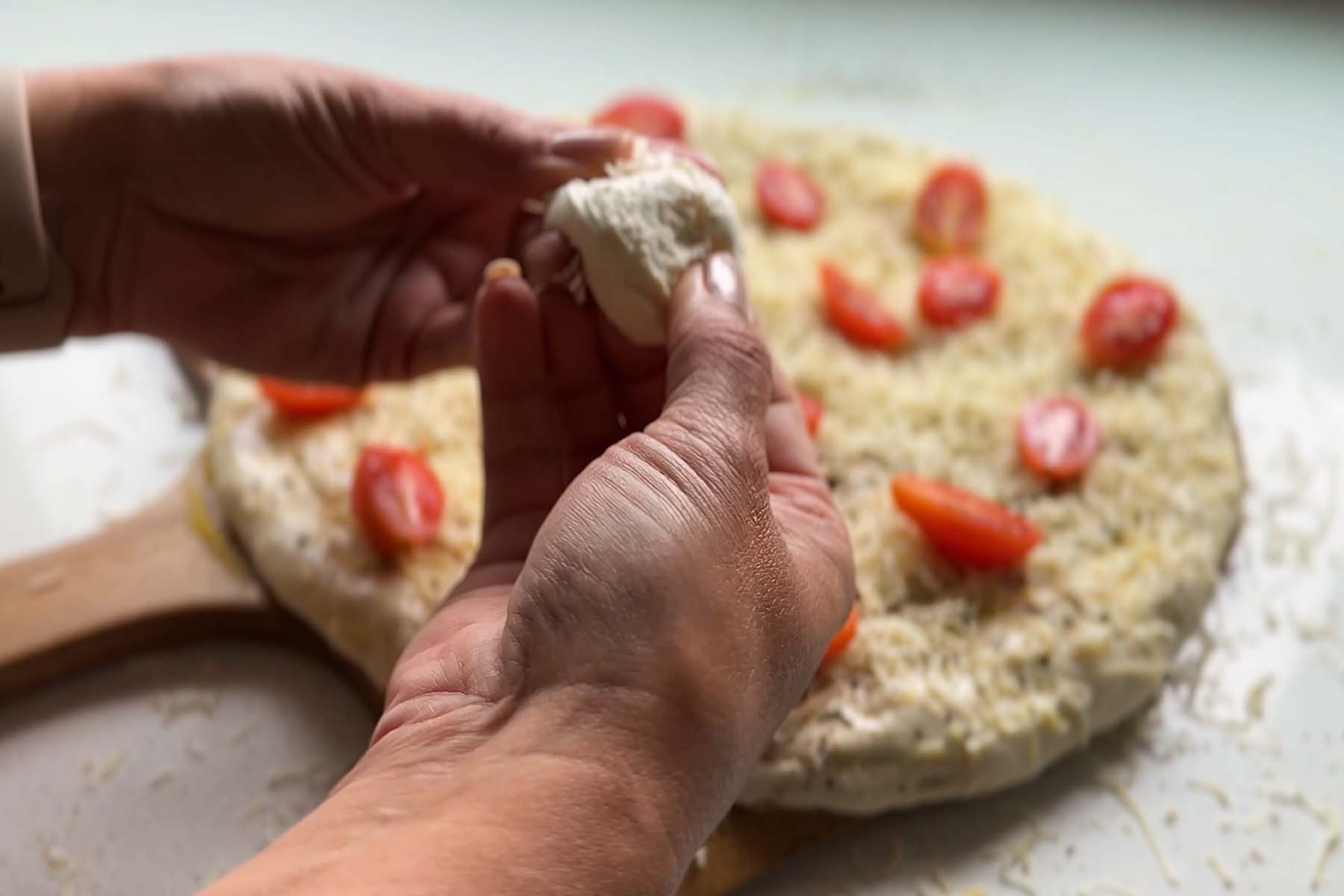 A mozzarella ball is torn into pieces.
