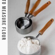 A measuring cup with flour in it with the text how to measure flour.