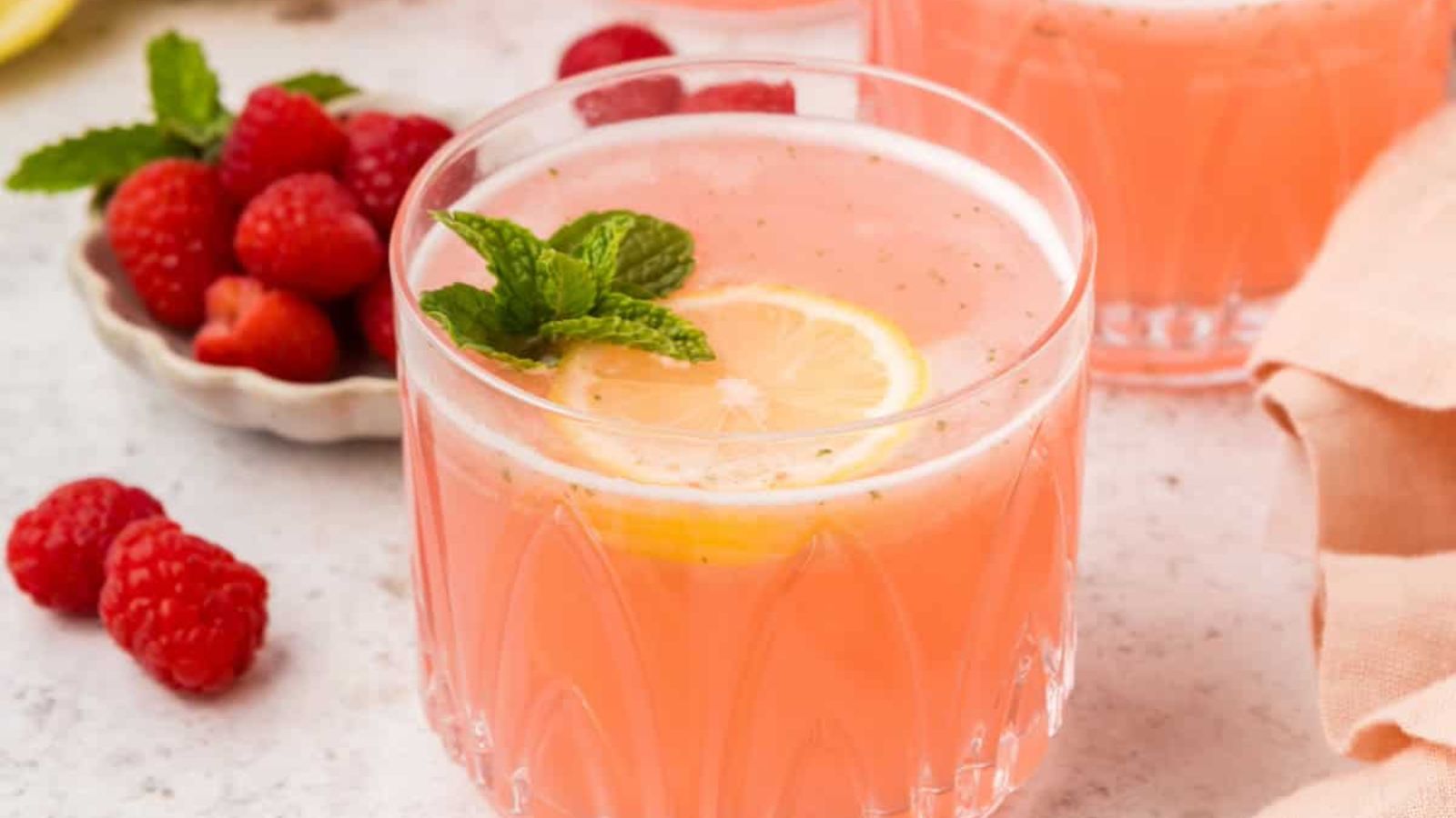 Pink lemonade in a glass with ice and mint.