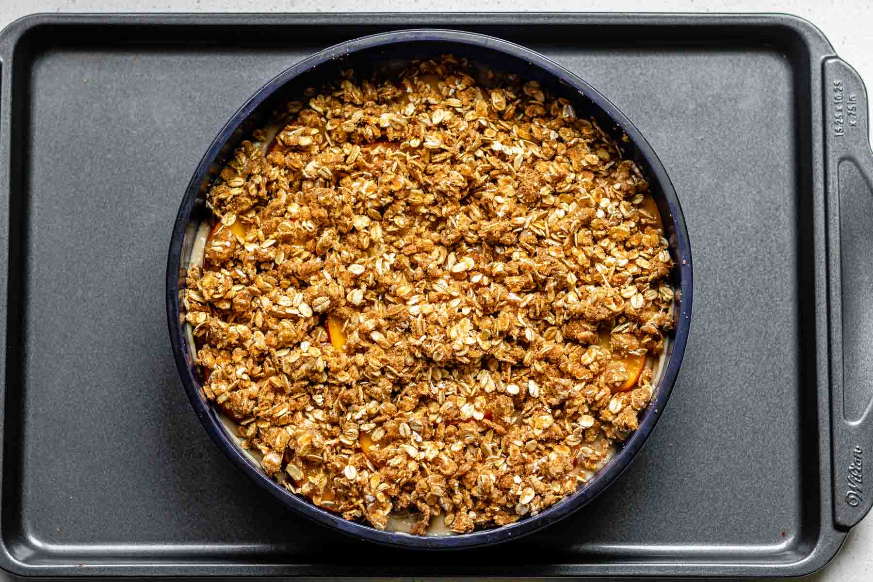 A cake pan with batter topped with oats.