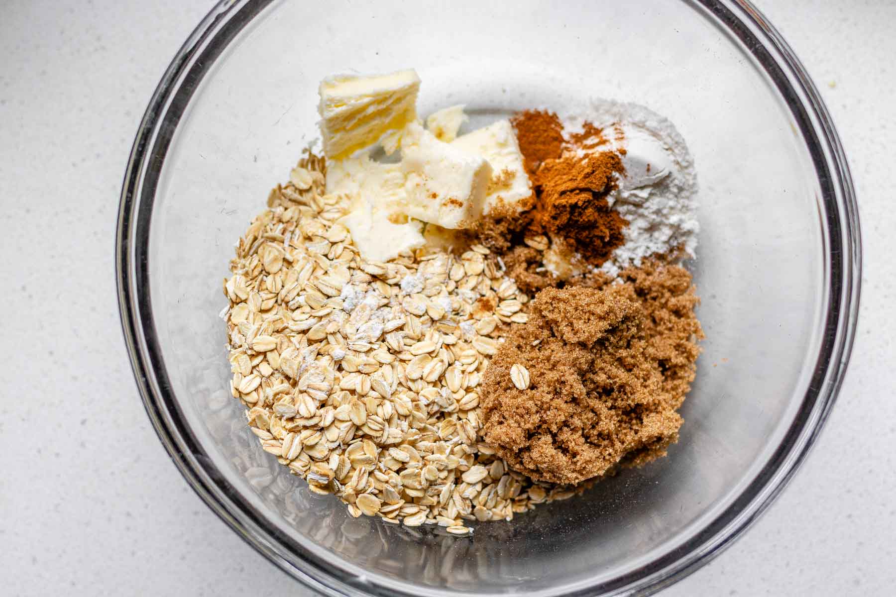 A bowl with butter, brown sugar, cinnamon, flour, and oats.