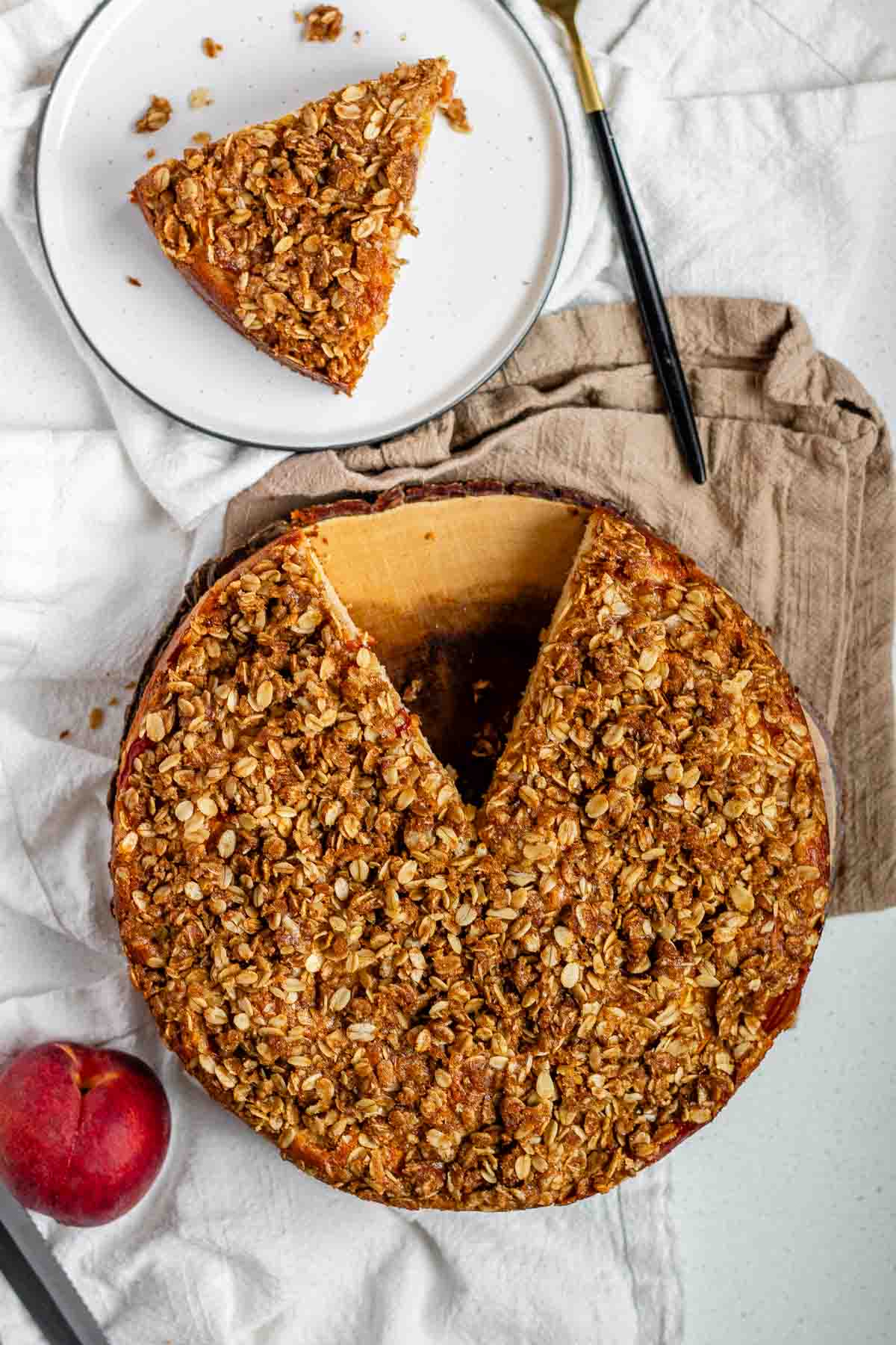 Cake with peaches inside and crumbled oats on top.