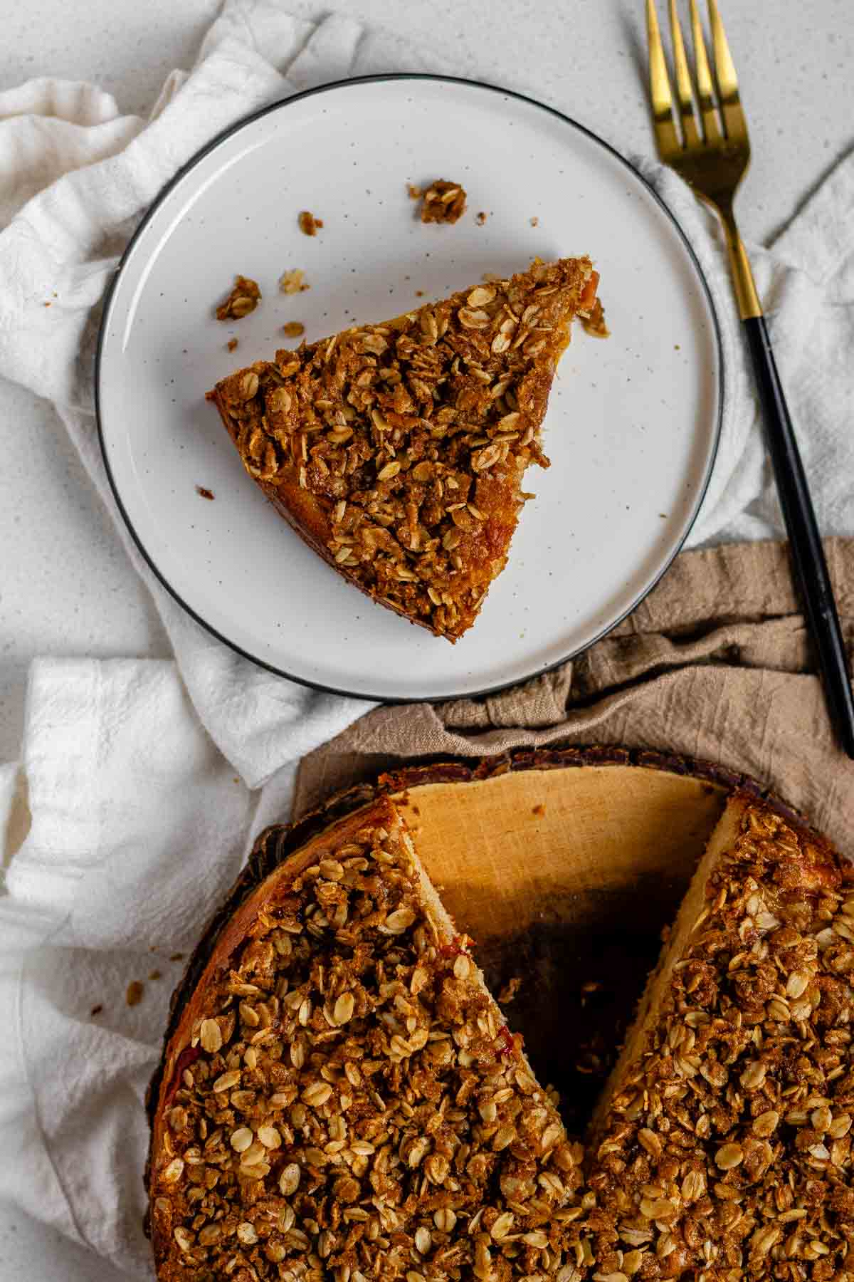 Cake with peaches inside and crumbled oats on top.