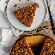 Cake with peaches inside and crumbled oats on top with the text peach crumble cake.