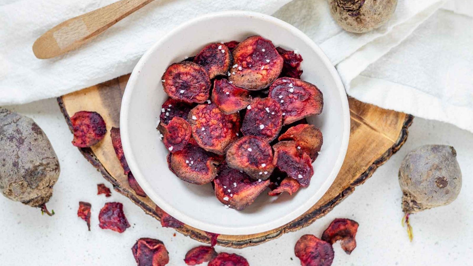 Beet chips in a bowl, topped with large flake salt.