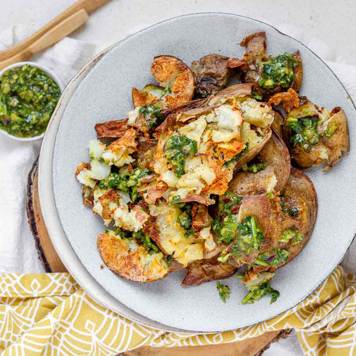Cooked potatoes on a plate with green sauce.
