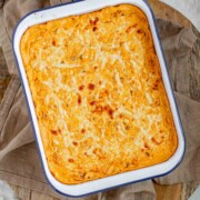 Golden baked buffalo chickpea dip fresh from the oven with melted cheese on top.