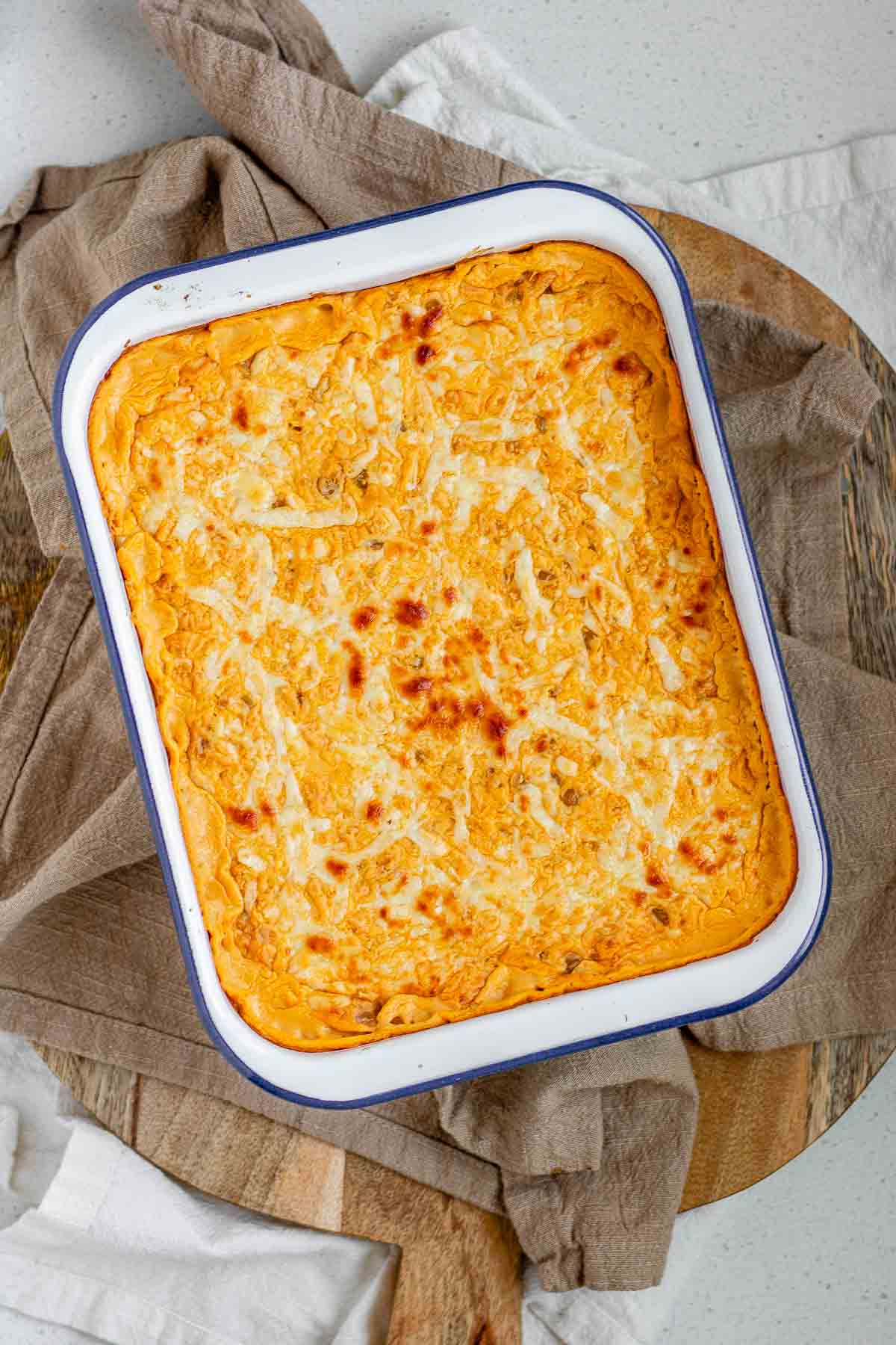 Golden baked buffalo chickpea dip fresh from the oven with melted cheese on top.