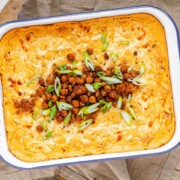 Golden baked buffalo chickpea dip fresh from the oven with melted cheese and pan-fried crispy chickpeas on top.
