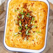Golden baked buffalo chickpea dip fresh from the oven with melted cheese and pan-fried crispy chickpeas on top.