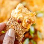 Spoonful of cheesy buffalo chickpea dip being scooped from the baking dish with the text buffalo chickpea dip.