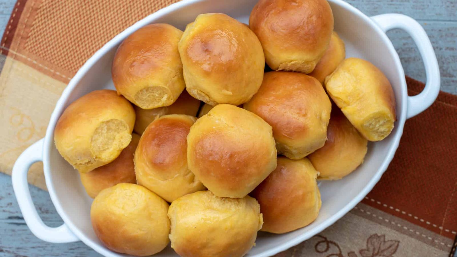 A white baking dish full of sweet potato rolls.