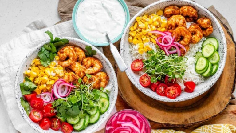 Bowls with rice, shrimp, and fresh vegetables.