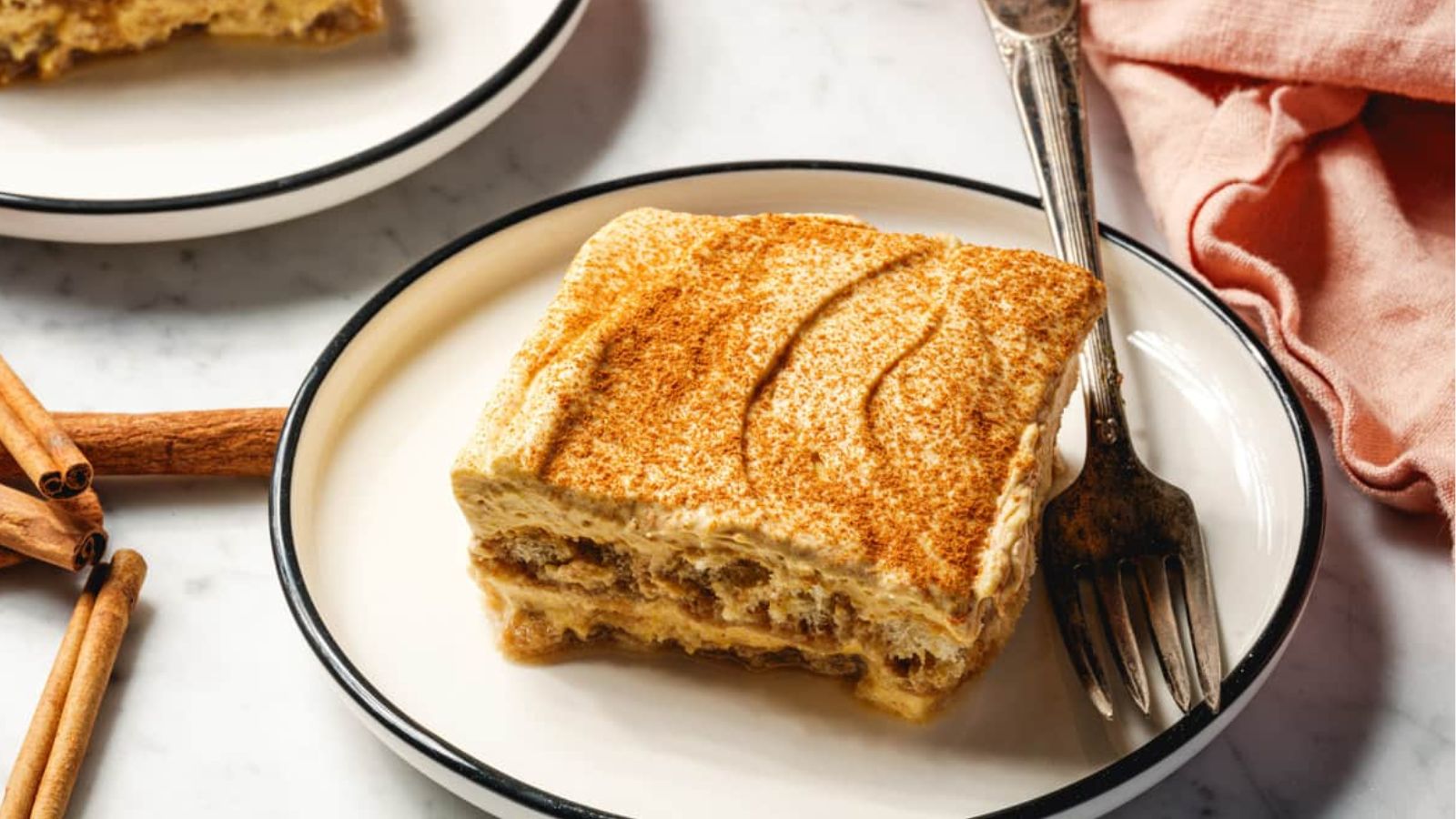 A layered cake on a plate with a fork.