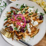 Crispy homemade Dukkah Fries served with tahini yogurt sauce, feta, olives, and pickled red onions.