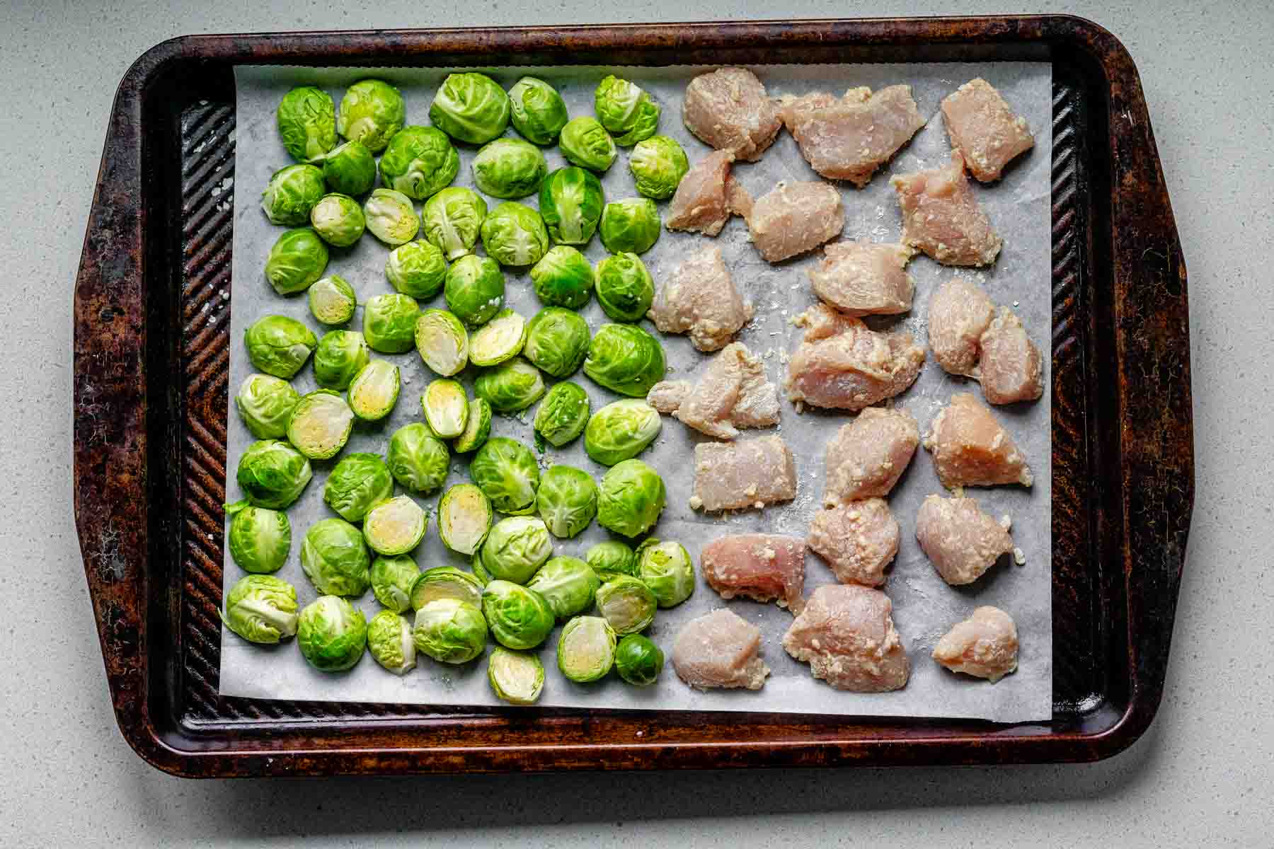 Sheet pan with spicy sesame chicken and Brussels sprouts.