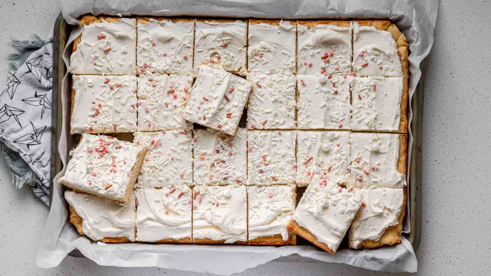 Stacked square cookies bars with icing and sprinkles.