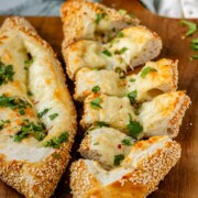 Boat-shaped baked dough filled with melted cheese sliced.