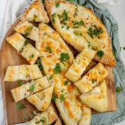 Boat-shaped baked dough filled with melted cheese sliced with the text cheese pide.