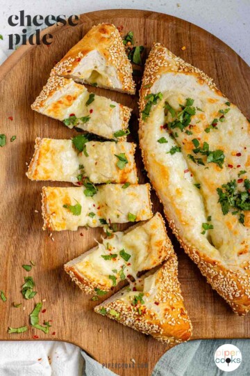 Boat-shaped baked dough filled with melted cheese sliced with the text cheese pide.