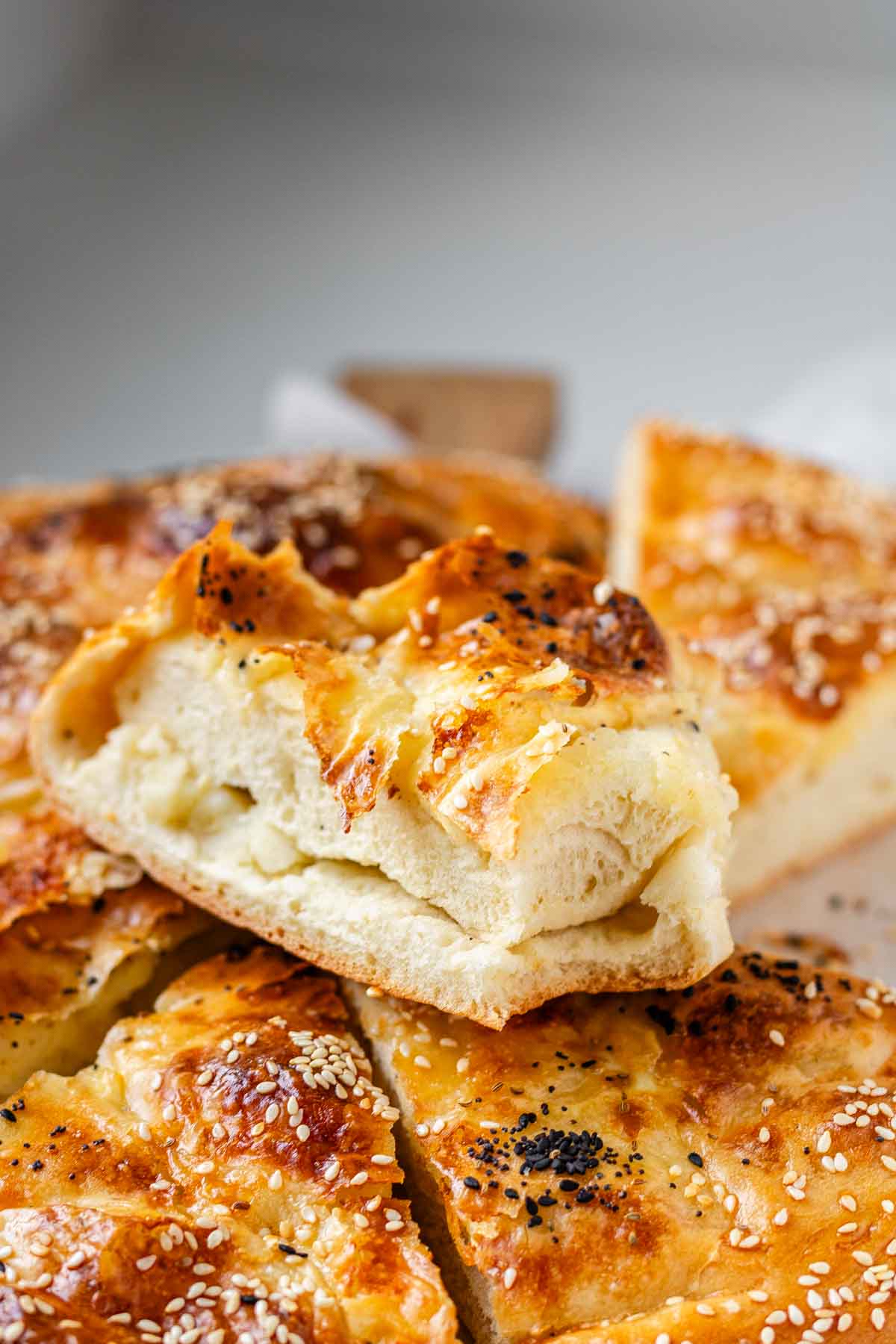 Sliced round flatbread topped with seeds.