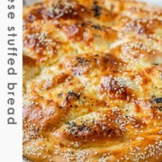 Round flatbread topped with seeds with the text cheese stuffed bread.