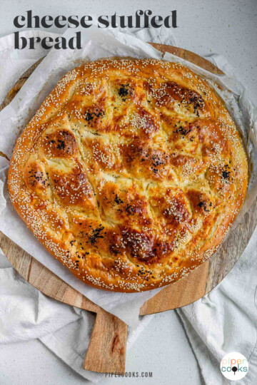 Round flatbread topped with seeds with the text cheese stuffed bread.
