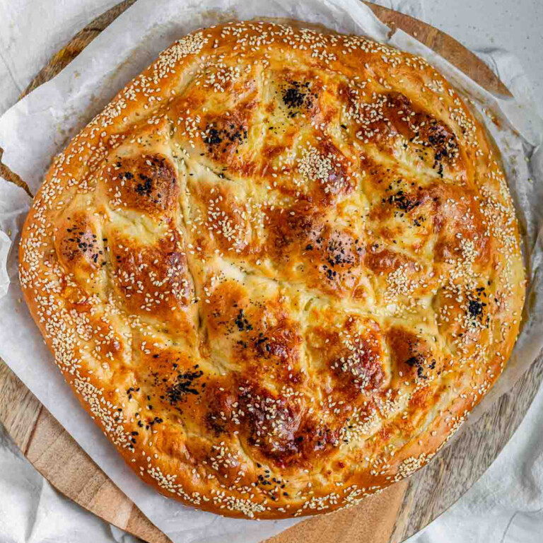 Round flatbread topped with seeds.