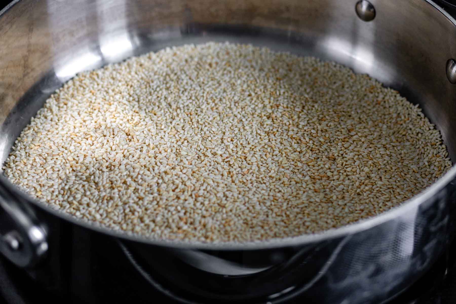 Toasting sesame seeds in a dry skillet until golden brown.