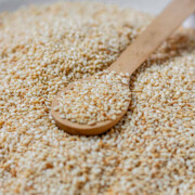Golden toasted sesame seeds are cooling on a plate with the text How to toast sesame seeds.