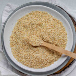 Golden toasted sesame seeds cooling on a plate.