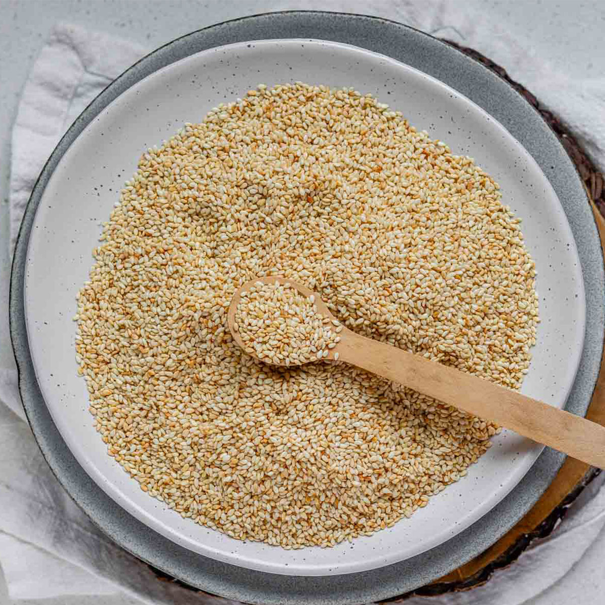 Golden toasted sesame seeds cooling on a plate.