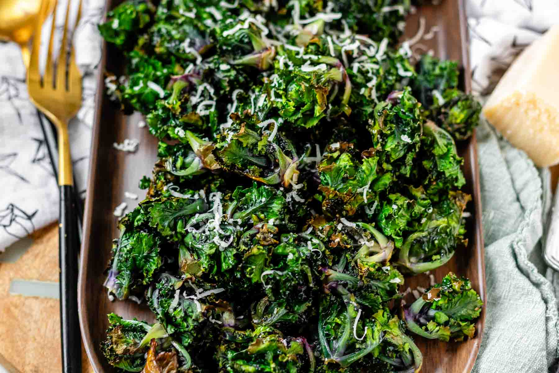 Roasted kalettes on a platter, topped with Parmesan cheese.