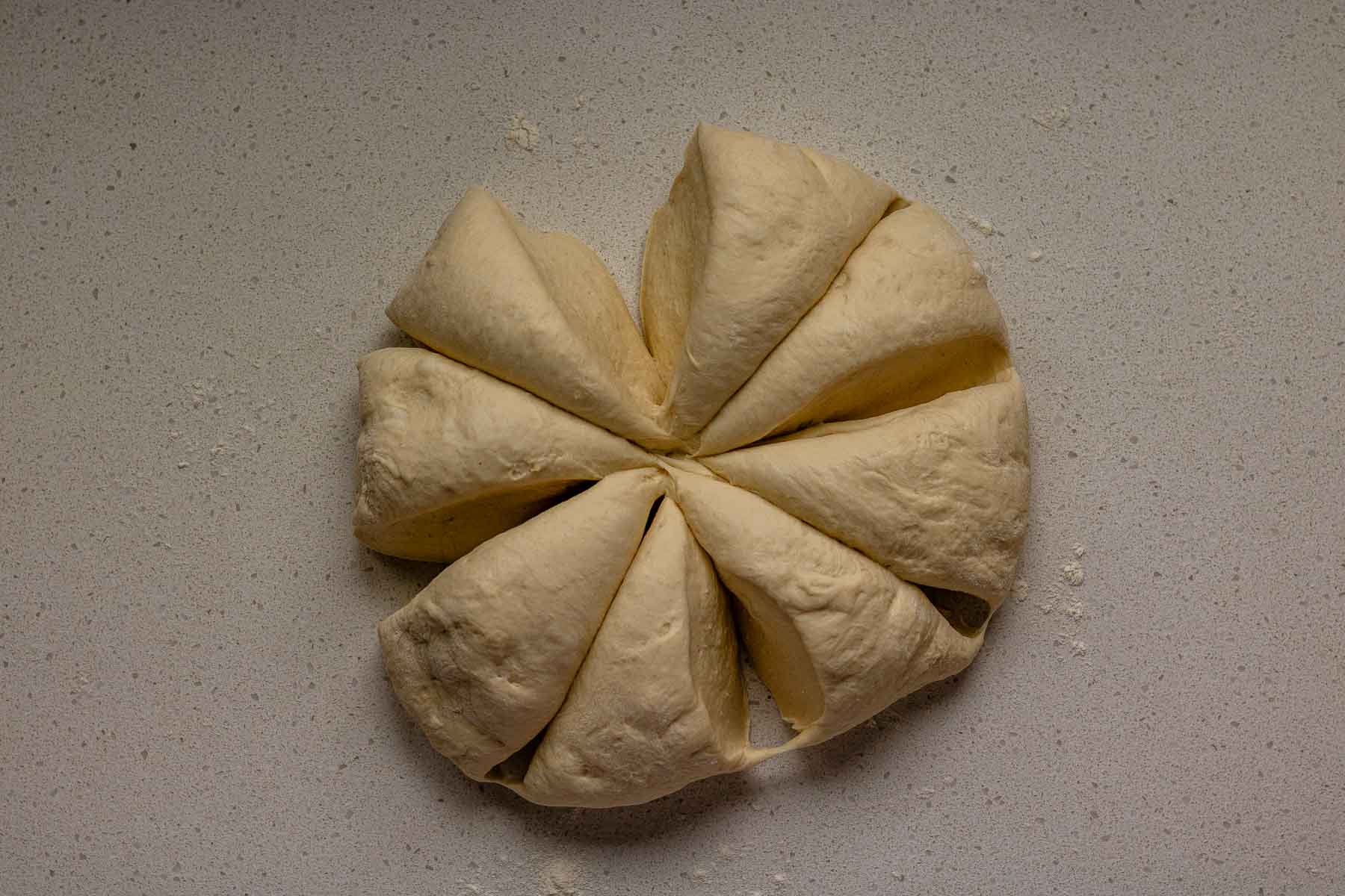 Dough on a counter, cut into 8 triangles.
