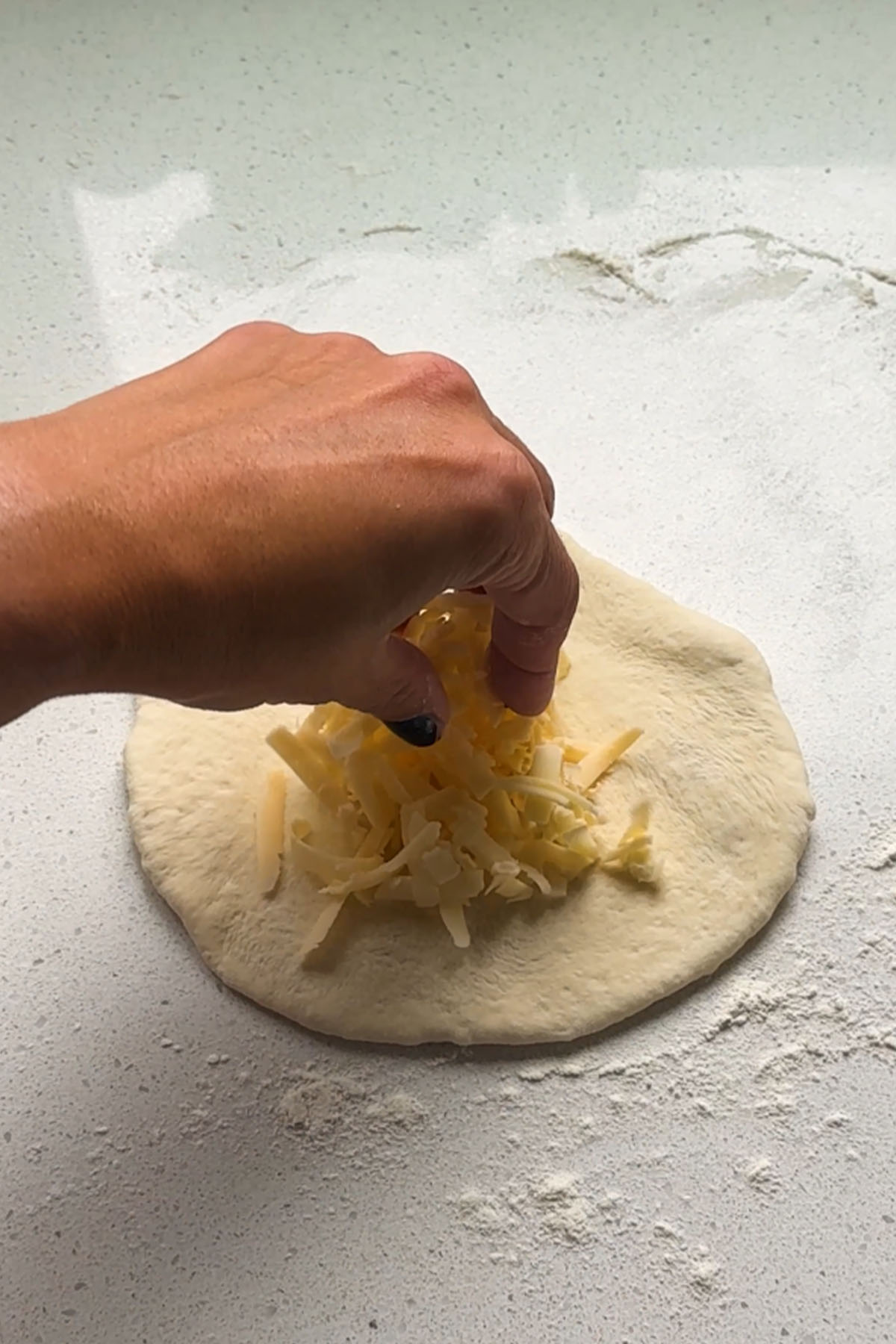 Cheese layered on top of a rolled piece of dough.