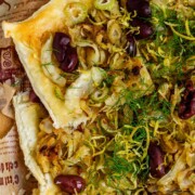 Baked puff pastry topped with fennel, onion, black olives, fresh dill, and lemon zest.