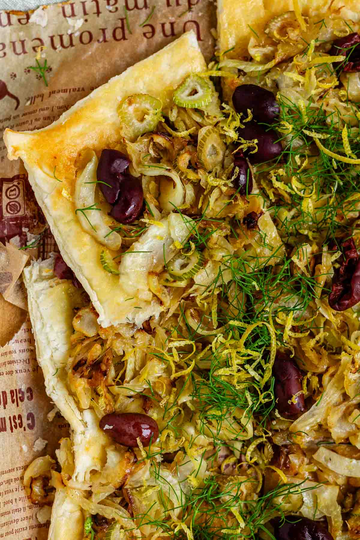 Baked puff pastry topped with fennel, onion, black olives, fresh dill, and lemon zest.
