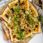 Baked puff pastry topped with fennel, onion, black olives, fresh dill, and lemon zest.